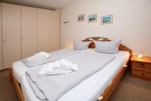 een slaapkamer met 2 bedden en witte lakens bij Waldstraße 19a, Whg 21, Feriendomizil am Südstrand in Wyk auf Föhr