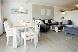 uma cozinha e sala de estar com uma mesa e um sofá em Am Flugplatz 1a, Whg 4, Haus Halligblick em Wyk auf Föhr