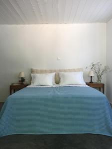 a bedroom with a blue bed with two night stands at Aνεξάρτητη παραδοσιακή πέτρινη κατοικία in Kórinthos