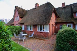 a brick house with a table and chairs in front of it at Ohl Dörp 22 Pastoratshof, Haus 5 in Wrixum