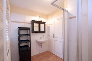 a bathroom with a sink and a mirror at Ohl Dörp 22 Pastoratshof, Haus 5 in Wrixum +7 photos