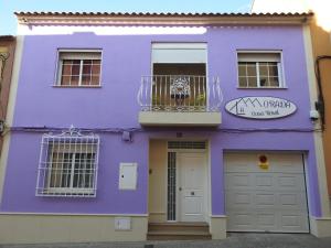 Bolaños de CalatravaにあるLa Morada Casa Ruralの紫色の家(バルコニー、ドア付)