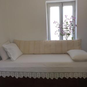 un divano in una stanza con finestra di Aνεξάρτητη παραδοσιακή πέτρινη κατοικία a Kórinthos