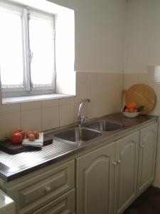 a kitchen with two sinks and two windows at Aνεξάρτητη παραδοσιακή πέτρινη κατοικία in Kórinthos