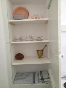 un estante con platos y tazones. en Aνεξάρτητη παραδοσιακή πέτρινη κατοικία en Kórinthos