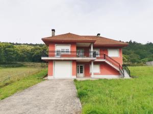 a red and white house with a balcony at Casa da Pioxa in Camariñas