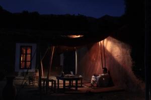 una persona seduta sotto una tenda di notte di Gîte Imarin ad Agouti