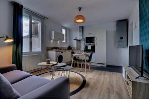 un salon avec un canapé et une cuisine dans l'établissement Appartement "PANNA" centre ville de VITRÉ, à Vitré 6 autres photos