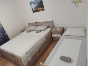 a bedroom with two beds and a night stand at Apartmani Marija in Sveta Nedelja