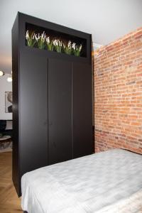 a bed with plants on top of a brick wall at Keskväljaku apartment - with sauna and AC in Võru