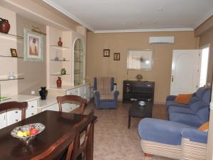 a living room with a blue couch and a table at La Morada Casa Rural in Bolaños de Calatrava