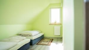 2 camas individuales en una habitación con ventana en Domek POD GOLCOWEM, en Limanowa
