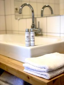 dwie butelki dezodorantów siedzące na zlewie w łazience w obiekcie Bed and Breakfast De Biesbosch - in 't Riet w mieście Drimmelen