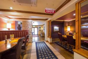 a restaurant with a table and chairs and a sign at Charter Hotel Bournemouth in Bournemouth +2 photos