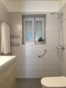 Un baño con inodoro y ventana. en Aνεξάρτητη παραδοσιακή πέτρινη κατοικία, en Kórinthos