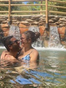 a man and a woman in the water in a fountain at Thermas Paradise Residence in Rio Quente
