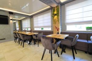 a restaurant with wooden tables and chairs and windows at Altin Palace in Komrat