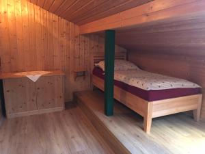 um quarto com uma cama num chalé de madeira em Stapflhof em Bad Aussee