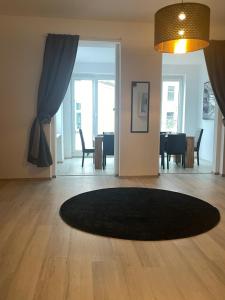 uma sala de estar com um tapete preto num piso de madeira em Old town Apartments , Perfekt für Messe 15min em Dusseldorf