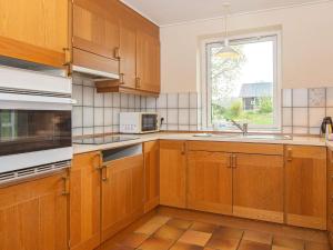 una cucina con armadi in legno e una finestra di 6 person holiday home in Glesborg a Glesborg