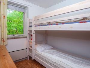 a bunk bed room with two bunk beds and a window at Serene Seaside Retreat at Hegedal-By Traum in Glesborg