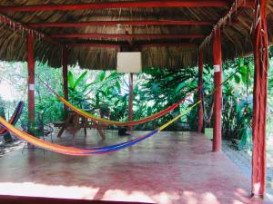 a hammock in a pavilion with a table at Mana Kai Camping & Cabins in San Ignacio