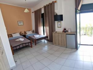 a room with two beds and a table and a kitchen at By Captains Studio in Ierápetra