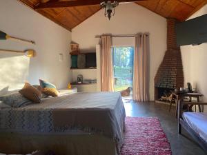 a bedroom with a bed and a large window at Pousada Chalés da Lua in Munhoz