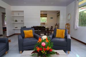 a living room with two blue chairs and a table at Fare Omoe in Fare