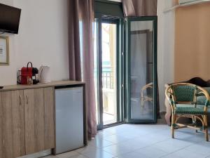 a kitchen with a sliding glass door leading to a balcony at By Captains Studio in Ierapetra