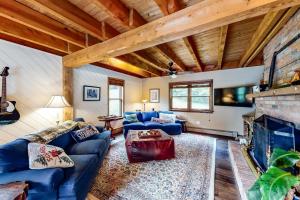Higgins Lodge في Warren: غرفة معيشة مع أريكة زرقاء ومدفأة