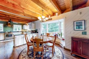 cocina con techo de madera, mesa y sillas en Higgins Lodge, en Warren