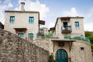 a building with a blue door and a stone wall at Napoleon Zaglis Guesthouse in Kalarrites +25 photos