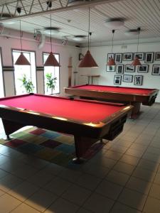two pool tables in a large room with windows at Uncle Joe's in Visby