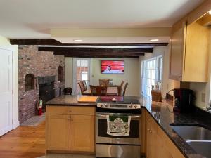 a kitchen with a stove and a living room at Mt Holly SKI & LAKE HOUSE 4 and 2 bedroom house, 2 separate homes, 2 bathrooms each, 8 mins to Okemo Mountain in Mount Holly