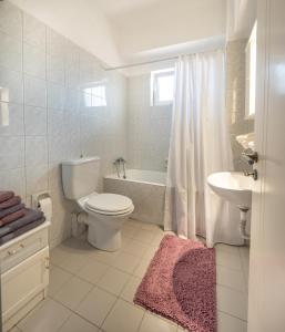 a bathroom with a toilet and a tub and a sink at Ιάνθη Ianthi apartment in Heraklio Town