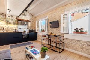 a kitchen and living room with a brick wall at Art Loft Venetian Well in Corfu Town