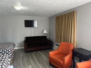 a hotel room with a bed and a chair at Wiarton Willys Inn in Wiarton
