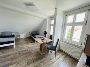 uma sala de estar com uma mesa e um sofá em Anhalt Pension em Coswig