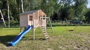 een speeltuin met een glijbaan en een playset bij Te Domki in Łukęcin