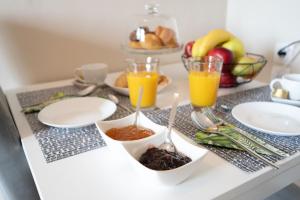 約阿尼納的住宿－Dream House Ioannina，一张桌子,上面放有盘子和橙汁杯