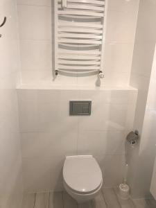 a white bathroom with a toilet and a window at Bliżej Morza Apartament 57 in Kołobrzeg +29 photos