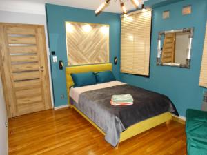 1 dormitorio con 1 cama con paredes azules en APPARTEMENTY COCO MANGO, en Bourges