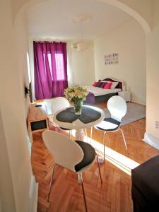 sala de estar con mesa, sillas y cama en Apartment Central, en Belgrado