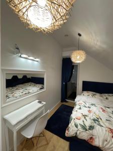 a bedroom with a bed and a white desk at Blue Wave Garden in Dziwnówek