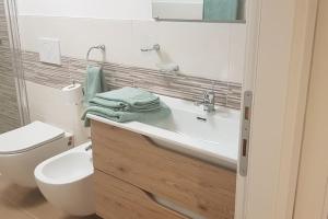 a white bathroom with a sink and a toilet at Appartamento Carta da Zucchero in Riva del Garda