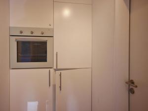 einen weißen Kühlschrank mit einer Mikrowelle darüber in der Unterkunft Fewo Sauerlandglück mit MeineCardPlus in Willingen