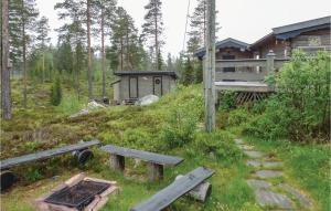 a cabin in the woods with a bench in the grass at Amazing Home In Ljrdalen With 3 Bedrooms And Sauna in Ljørdal