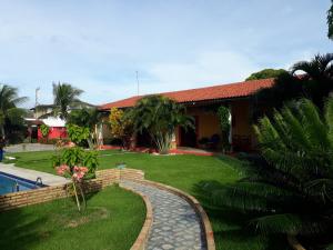 a house with a garden and a swimming pool at chácara ouro verde in Beberibe