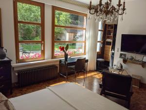 a living room with a table and some windows at La Closerie in Droue-sur-Drouette